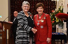Rhodes (left), after her investiture as a Companion of the New Zealand Order of Merit, by the governor-general, Dame Patsy Reddy, in 2017 Lesley Rhodes CNZM investiture.jpg