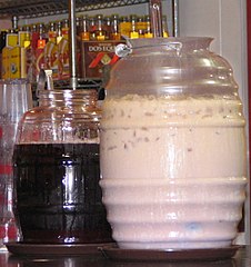 Deux grosses bouteilles d'aguas frescas dans un restaurant mexicain à Seattle, avec des bouteilles de Jamaica (hibiscus) et de horchata.