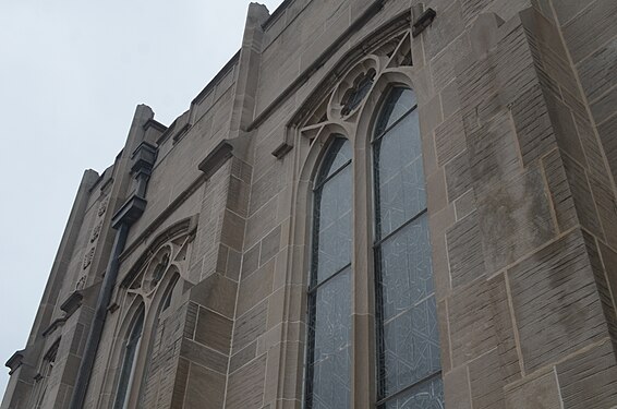 A gray stone Presbyterian Church on a cloudy day