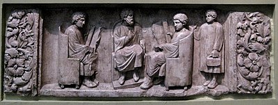 Roman relief of a teacher with three students, c. 180–185 AD (Source: Wikimedia)