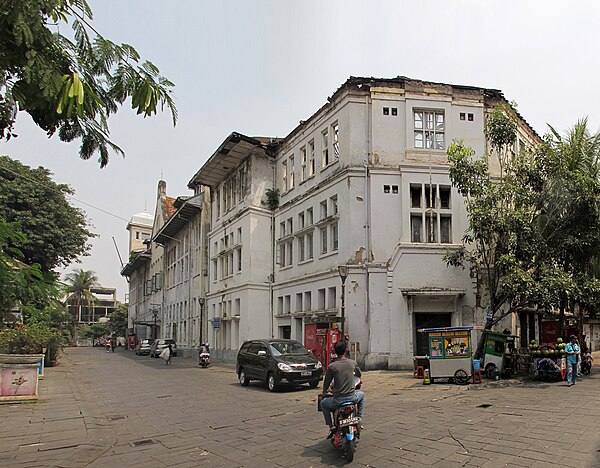 East facade of Cipta Niaga Building, formerly a bank office, has been left roofless and slowly deteriorates; the wooden interior exposed to the elemen