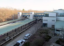 Platforms, footbridge, and station building viewed from the garage roof Route 128 station from garage roof, April 2016.JPG