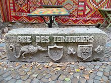 símbolos de la calle, tarasca, escudos de armas, tallados en una piedra reutilizada, al borde de la calle