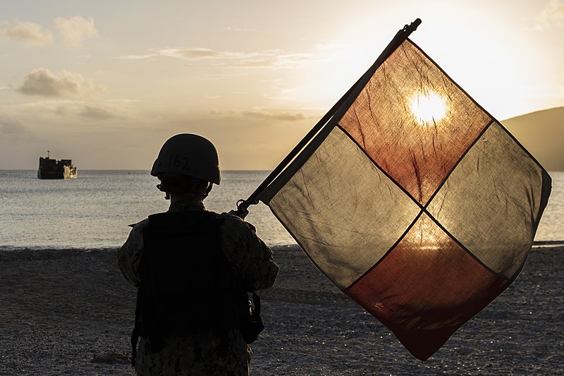 File:Sailor waves the Uniform flag, guiding a landing craft utility to shore. (37207237995).jpg