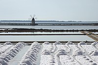Salt ponds in Trapani: harvesting salt. Windmill in the background. Author: Alessandro Giannini