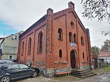 Niereferencyjny, murowany budynek synagogi z dachem dwuspadowym.