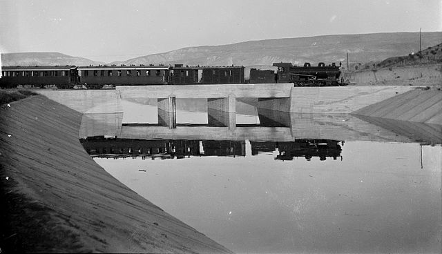 Steam powered passenger train on bridge