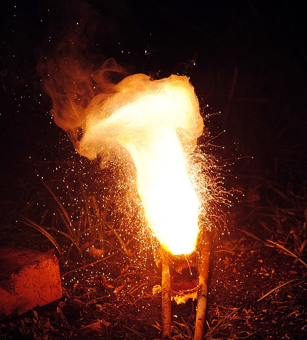 An exothermic thermite reaction using iron(III) oxide. The sparks flying outwards are globules of molten iron trailing smoke in their wake.