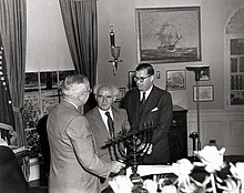 Truman in the Oval Office, receiving a Hanukkah Menorah from the prime minister of Israel, David Ben-Gurion (center). To the right is Abba Eban, ambassador of Israel to the United States. Truman receives menorah.jpg