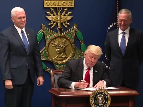 U.S. President Donald Trump signing the order at the Pentagon, with Vice President Mike Pence (left) and Secretary of Defense Jim Mattis