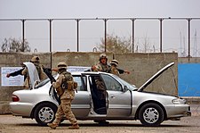 U.S. Marines check vehicles at a checkpoint, Ramadi, 20 February 2005 US Navy 050220-N-6967M-138 U.S. Marines and Sailors, assigned to 1st Marine Division, 2nd Battalion, 5th Marines, search Iraqi vehicles and their occupants at a Ramadi, Iraq checkpoint.jpg