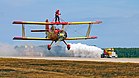 Gene Soucys Showcat (Grumman G-164) und Teresa Stokes als Wing-Walker am 25. September 2004 vor dem Jet Truck „Shockwave“ bei der Air Show der Naval Air Station Oceana KW 17 (ab 25. April 2021)