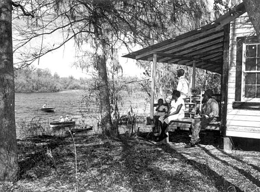 African American families watch boats on the Suwannee River c 1950