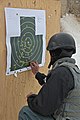 An Afghan Uniformed Police officer places circle stickers on the holes where his 7.62X39 mm rounds hit the target at Swanson Small-Arms Range on Forward Operations Base Shank, Logar province, Afghanistan, Feb 120201-A-BZ540-006.jpg