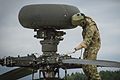 An Apache attack helicopter pilot of 4 REGT AAC inspects his aircraft while he awaits tasking. MOD 45160148.jpg