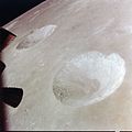Craters Carmichael and Hill. The black shape on the left is a thruster on the LM. It was taken during the 13th orbit of the Moon by Dave Scott.