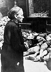 An elderly woman in front of the bodies of school children in Cologne, Germany, after a bombing raid Bundesarchiv Bild 146-1979-025-19A, Koeln, Kinderleichen nach Luftangriff.jpg