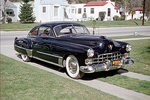 Кадиллак 1948 года с гнутым лобовым стеклом из двух половин. На автомобилях Cadillac такие лобовые стёкла появились ещё в 1948 модельном году[1].