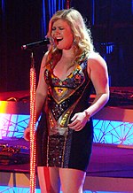 "About You Now" was compared to Kelly Clarkson's 2004 single "Since U Been Gone". Clarkson Live 2012.jpg
