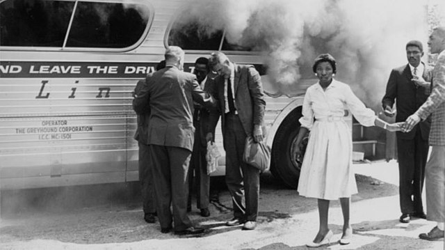 A Greyhound bus burns after being firebombed outside of Anniston, 14 May 1961.