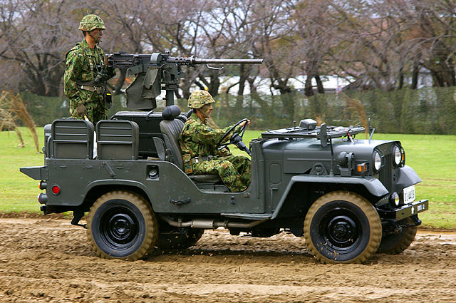 A Japan Ground Self-Defense Force military light truck armed with a heavy machine gun for anti-personnel harassment operations.