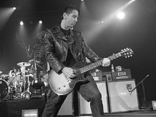 Джонни Уикершем әлеуметтік бұрмалаушылықта гитара ойнайды (Нью-Йорк, Нокиа театры, 2005 жылғы сурет Эрика Хардинг.)