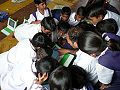 Teacher showing children OLPC XO-1 in India, Khairat.