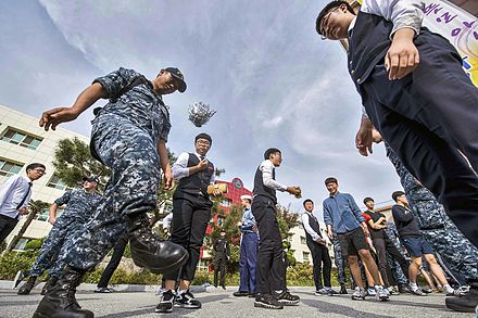 Sailors play Jegichagi with Korean students during a community relations event (30361247131).jpg