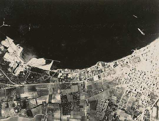 Aftermath of the battle showing an Italian battleship down by the bows and beached (far right)