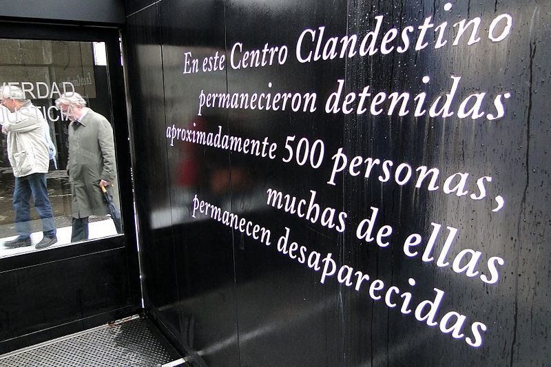 File:Genocide Scholars-IAGS Visitors Walk Past Memorial Sign - Olimpo Detention and Torture Center - Buenos Aires - Argentina.jpg
