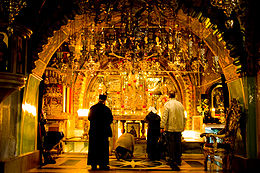 Eastern Orthodox pilgrims making prostrations at Golgotha in the Church of the Holy Sepulchre, Jerusalem. Greek Altar of Calvary.jpg