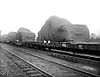 A string of flatcars carrying tanks under tarps