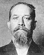 A black-and-white mug shot of Luigi Galleani, facing the camera with a full moustache and beard