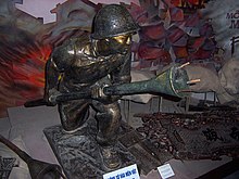 A statue of a Vietminh soldier holding a Lunge AT Mine. In Vietnamese the mine is called bom ba cang, literally means "three-clawed bomb". Lunge AT Mine.jpg