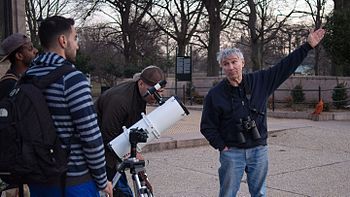 Man in Brooklyn's Prospect Park inviting passersby to use his telescope and talk about an astronomical phenomenon Man with a telescope in Prospect Park (92556).jpg