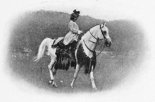 Fotografía en blanco y negro de una joven a caballo.