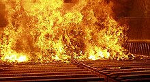 Municipal solid waste in the furnace of a moving grate incinerator capable of handling 15 metric tons (17 short tons) of waste per hour. The holes in the grate supplying the primary combustion air are visible. Movinggrate.jpg