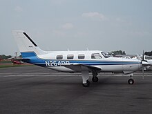 A white and blue aircraft parked on an airport apron