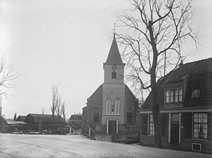 Overzicht van de westgevel met woningen nabij de omgeving van de kerk.