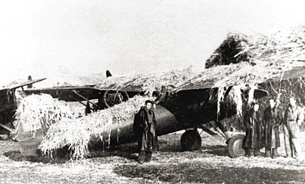 A camouflaged Polish P-11 fighter at a combat airfield