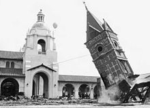 The clock tower of the original Santa Fe depot at Bay and Broadway is pulled to the ground by a steel cable attached to two yard locomotives as part of the grand opening celebration on March 7. San Diego Depot in 1915.jpg