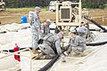Soldiers clear water away from fuel line couplings 150609-A-WO086-001.jpg