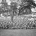Outdoor photo of a large group of seated men in uniform