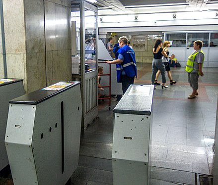 Ticket inspector and guard watching the turnstiles in Moscow Metro