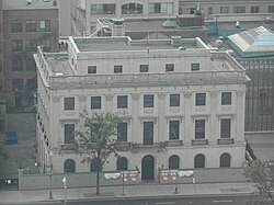 Square grey building seen from above and in front