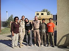 Winslow with US Army nurse, Iraqi medical workers, and two boys. Civil Military Operations Center clinic, Baghdad, 2006 Winslow CMOC staff Baghdad.jpg