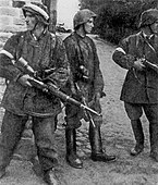 Warsaw Uprising 5 August 1944 in Gęsiówka. The men are dressed in captured German uniforms and armed with confiscated German weapons. From left: Wojciech Omyła "Wojtek", Juliusz Bogdan Deczkowski "Laudański" and Tadeusz Milewski "Ćwik". Milewski was killed on the same day. Omyla was killed several days later on 8 August 1944.