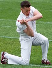 Junior Yell Leader Connor Joseph doing the "whoop" hand signal on the field at a football game. AggieYellLeader.jpg