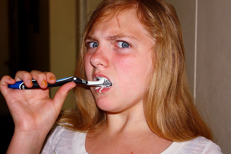 Annoyed Girl Brushing Teeth.jpg
