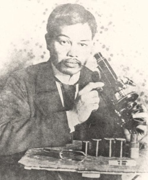 Antonio Luna poses with a microscope at the Institut Pasteur in Paris.